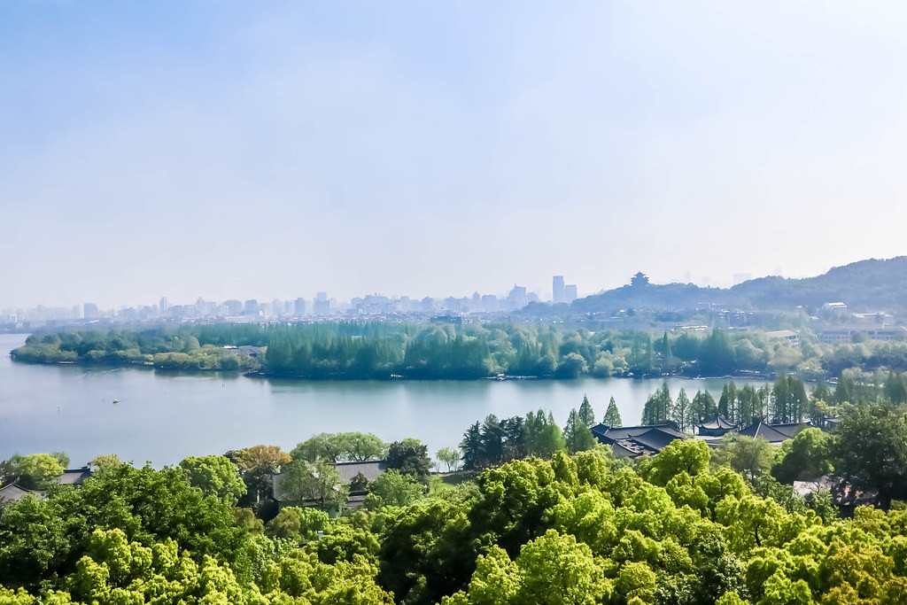 Aerial view of West Lake showing causeways, islands, and the Hangzhou cityscape