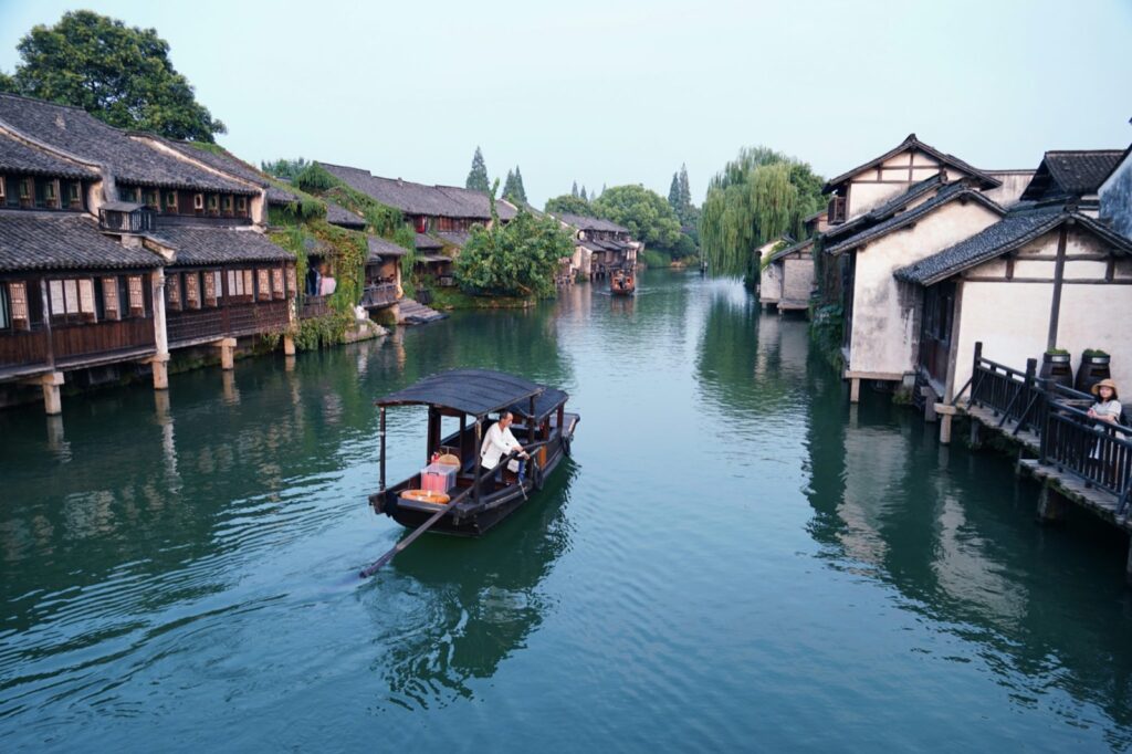 Traditional canal in Wuzhen water town at dusk, with stone bridges and lanterns