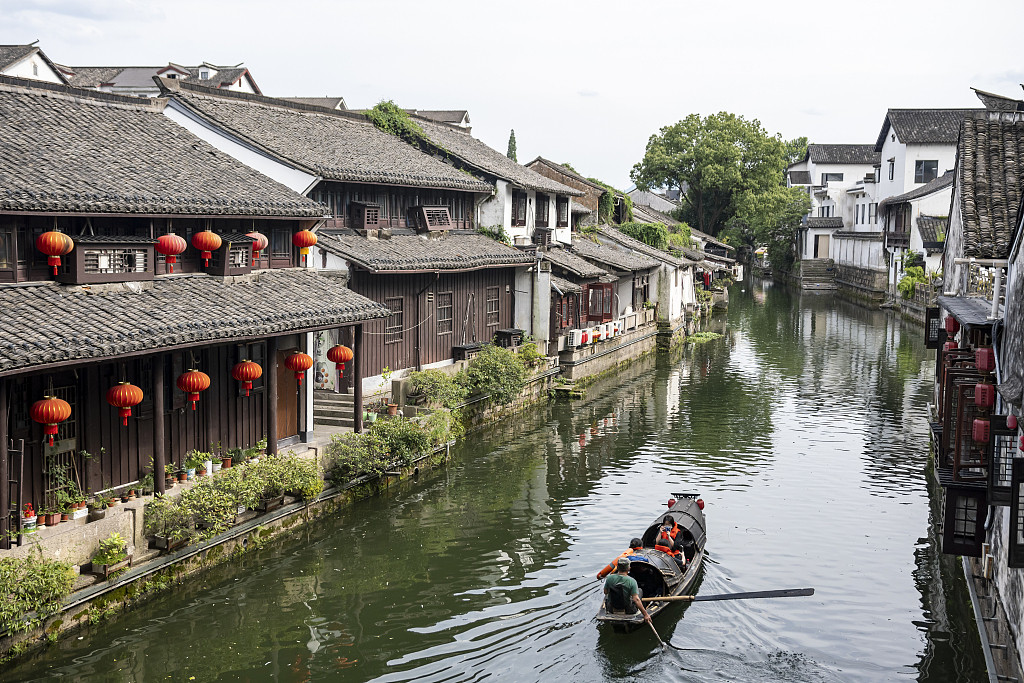 Shaoxing water town canal with traditional buildings and a small wooden boat