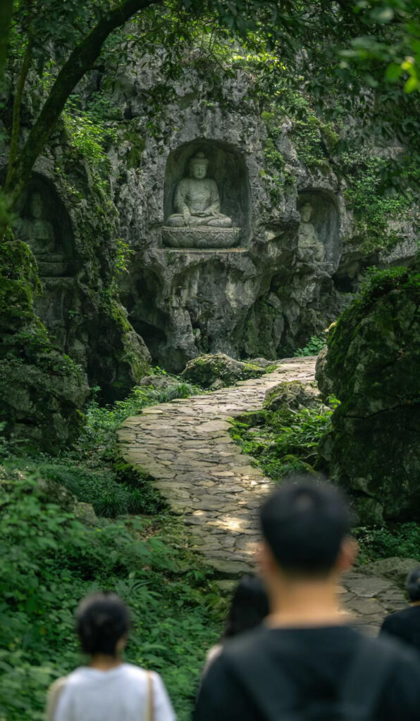 Lingyin Temple in misty rain with a large Buddha statue in the foreground